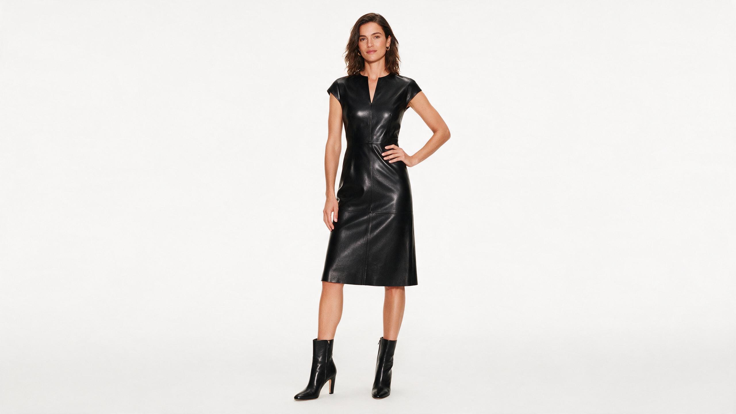 Woman wearing a black leather dress styled with boots